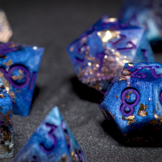 Photograph of blue dice with gold shimmers and purple numbering